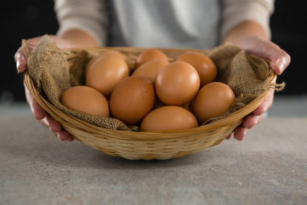 istock Woman holding basket with brown eggs 864595544