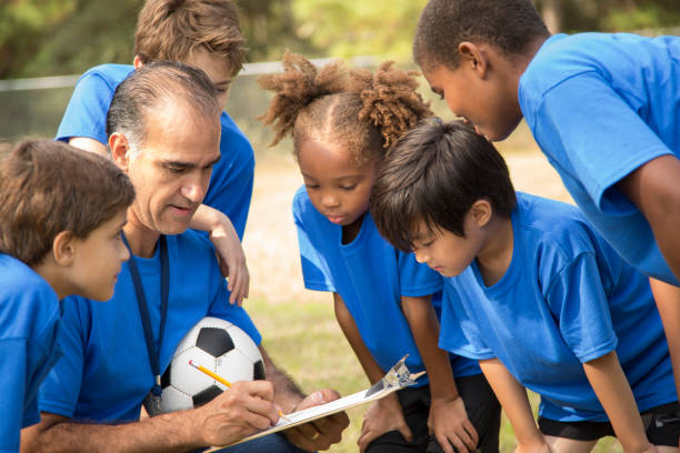 istock Soccer team coach explains next play to his children's team. 864597788