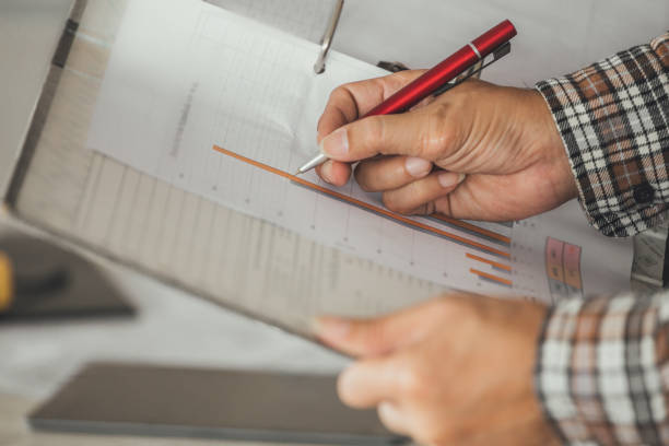 istock Management consulting with engineers working with blueprint and drawing on work table. 864597958
