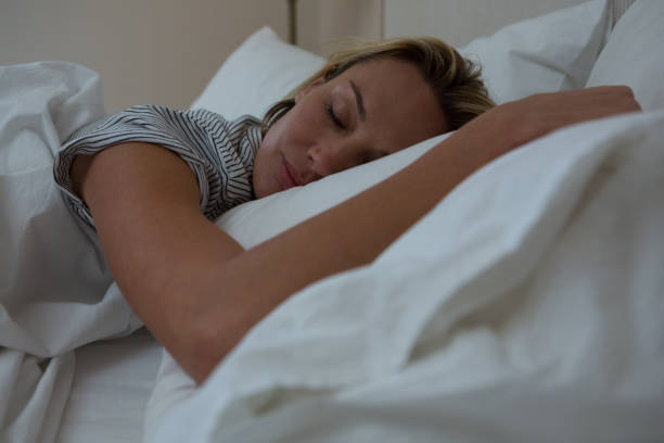 istock Woman sleeping peacefully on bed 864598650