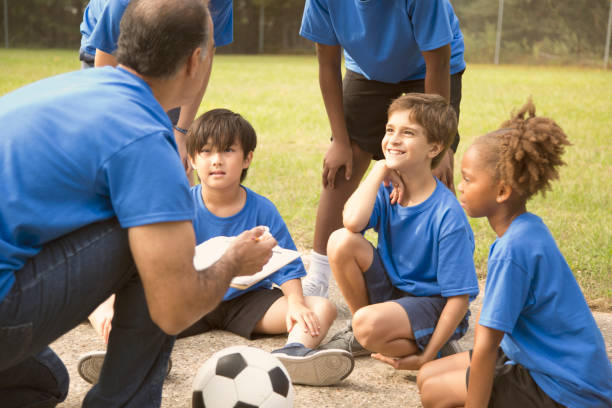 istock Soccer team coach explains next play to his children's team. 864599368