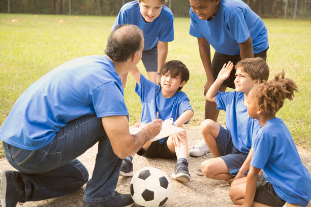 istock Soccer team coach explains next play to his children's team. 864600184