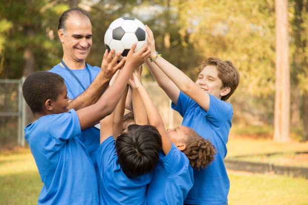 entraîneur de l’équipe soccer pour enfants fête la victoire avec ses joueurs. - championnat jeunes photos et images de collection