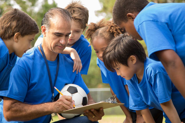 istock Soccer team coach explains next play to his children's team. 864600962