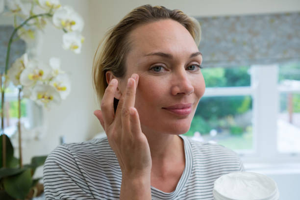 istock Woman applying moisturizer in bathroom 864603338