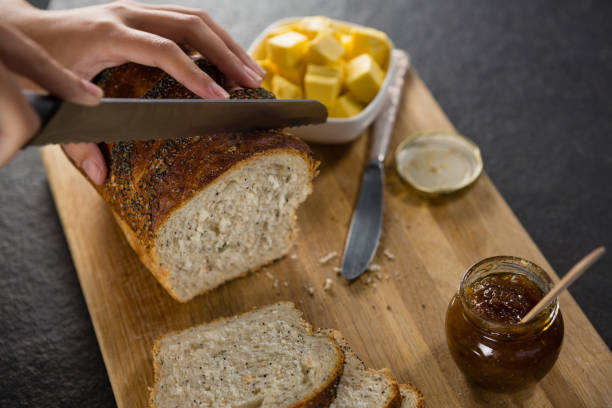 istock Woman cutting freshly baked multigrain bread 864605646