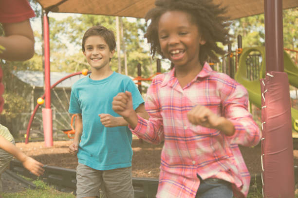 istock Multi-ethnic group of school children running on school playground. 864607116