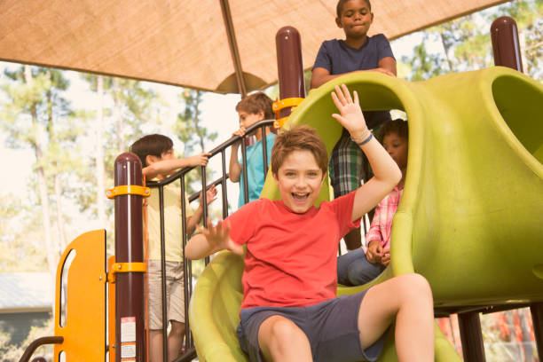 wieloetniczna grupa uczniów bawiących się na szkolnym placu zabaw. - child jungle gym playground laughing zdjęcia i obrazy z banku zdjęć