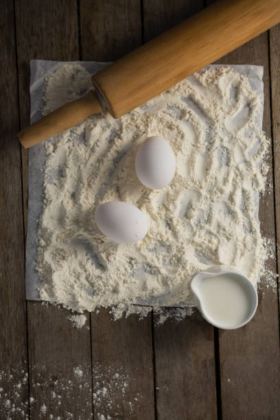 istock Flour, eggs and rolling pin placed over butter paper on a table 864613750