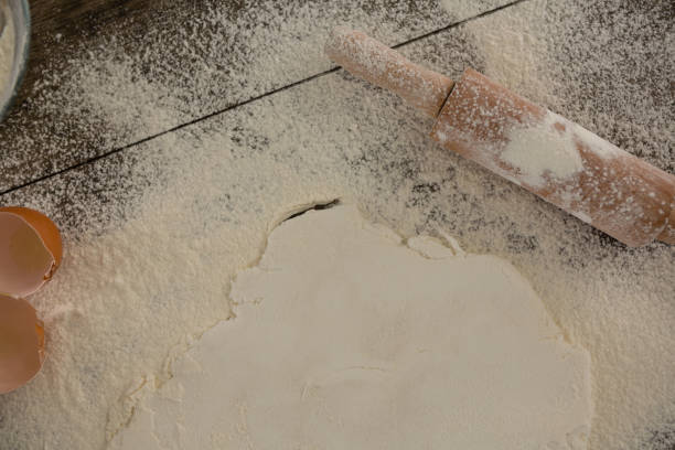 istock Flattened dough sprinkled with flour on a wooden table 864615448