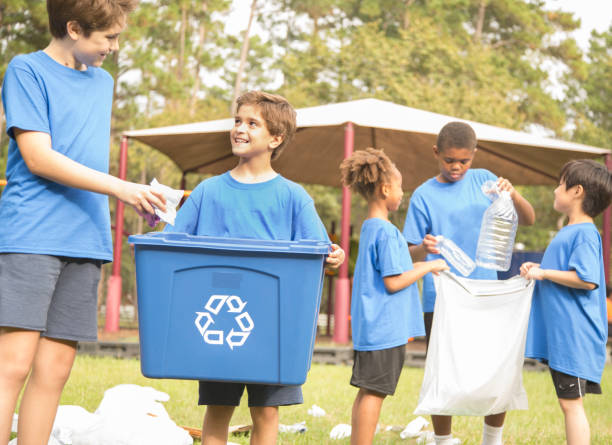 istock Multi-ethnic group of school children recycling at park. 864615710
