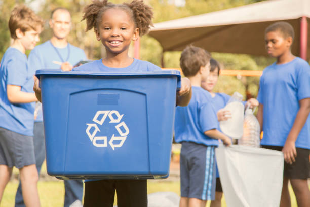 multi-ethnic group of school children recycling at park. - wasting time imagens e fotografias de stock