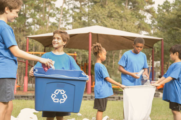 istock Multi-ethnic group of school children recycling at park. 864618340