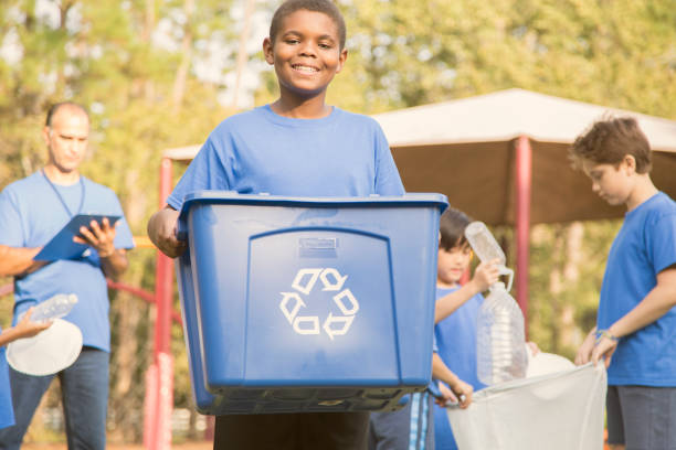 istock Multi-ethnic group of school children recycling at park. 864618554