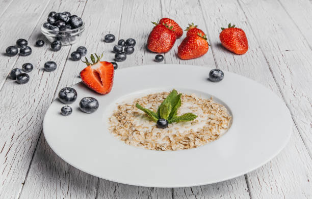 istock fresh Blueberries , strawberries and oatmeal on table 864638220
