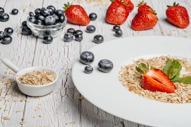 istock fresh Blueberries , strawberries and oatmeal on table 864638224