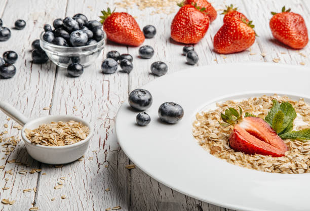istock fresh Blueberries , strawberries and oatmeal on table 864638404