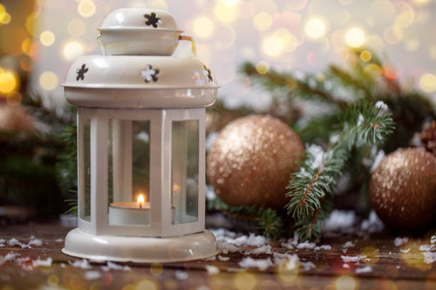 istock Lantern candle and Christmas tree over snow on wooden 864639598