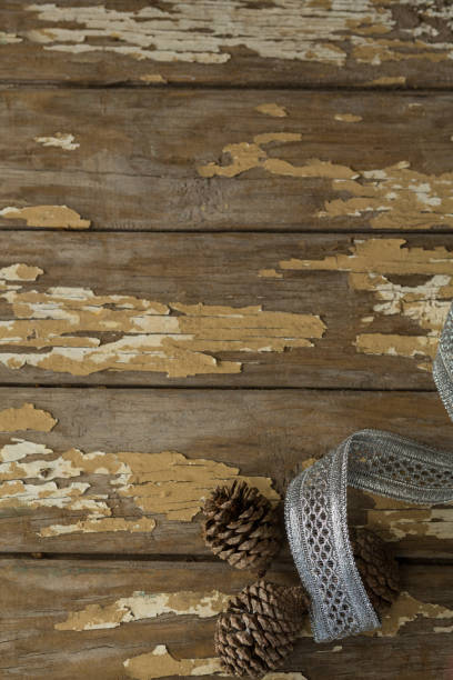 istock Pine cones with silver ribbon on wooden table 864645220