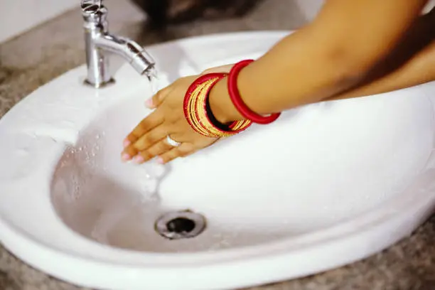 Washing hands in the wash basin.