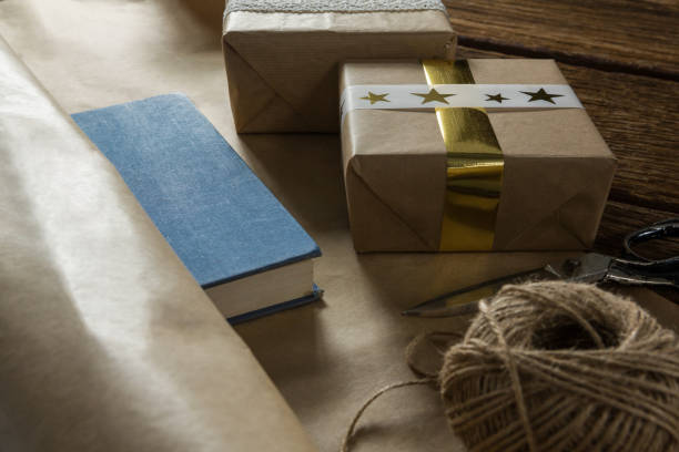 Close up of paper with gift box by scissor and thread spool