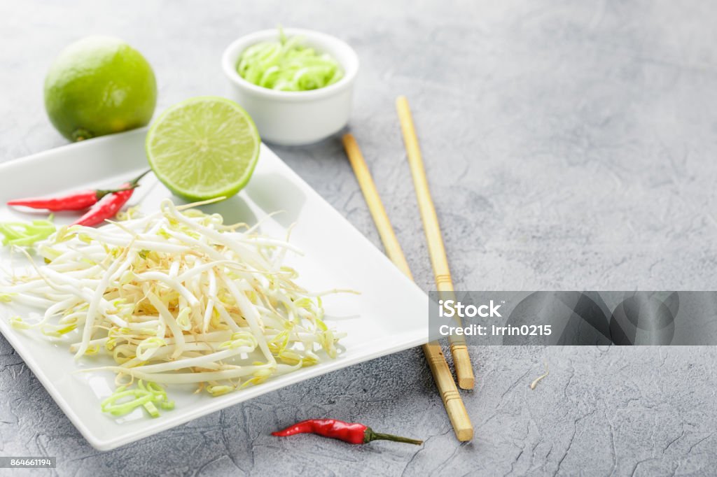 Bean sprouts in white plate. Fresh bean sprouts on white square plate and chopsticks. Concept of healthy foods, vegetarian food. Asia Stock Photo