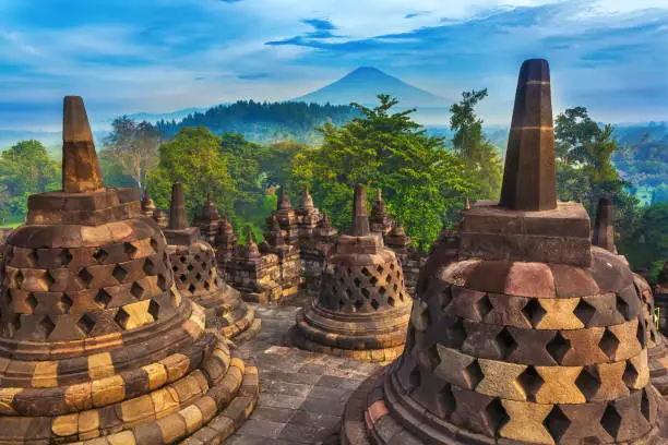 Candi Borobudur in the background of rainforest, morning mist and Sumbing Mountain.