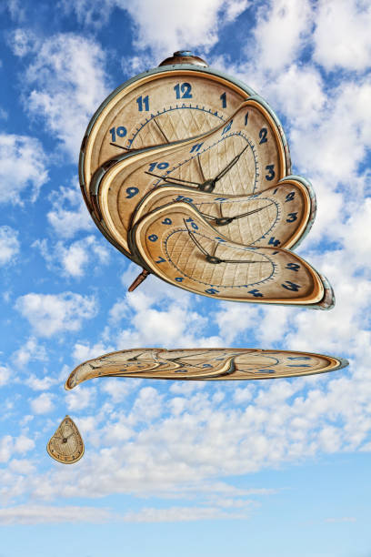 istock Surreal Alarm clock transforming and thawing on blue cloudy sky background. 864699454
