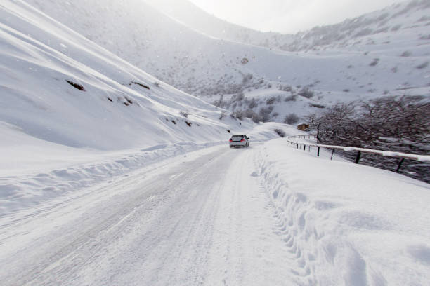 istock road with a car in winter in the mountains 864704182