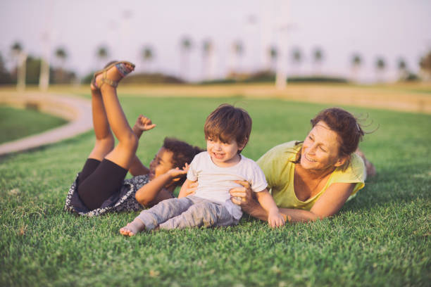 Young mother and her son enjoying sunset on a meadow with balloons. They are exploring nature together. Family time.