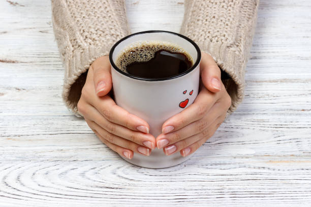 istock Woman's hands holding cup with coffee, top view 864704830