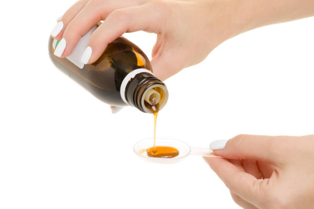 istock Female hand syrup for throat pour into a spoon 864713744