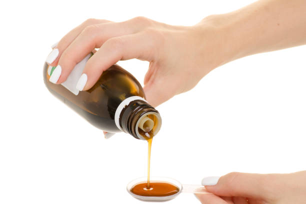 istock Female hand syrup for throat pour into a spoon 864713826