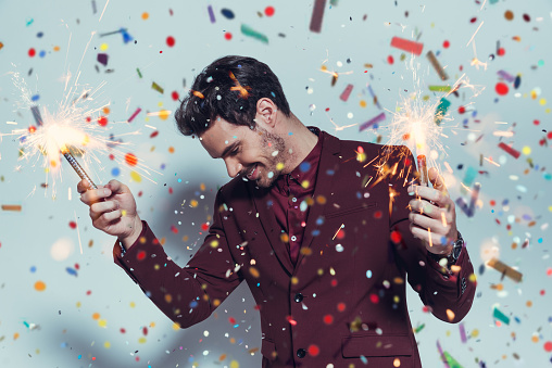 Handsome man with sparklers. Office party concept.