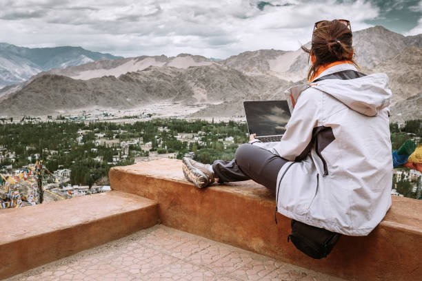 istock Traveler with laptop sits on top view point on the mountain valley 864749106
