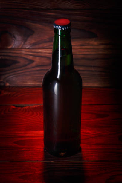 istock Bottles with beer on a brown wooden background 864753326