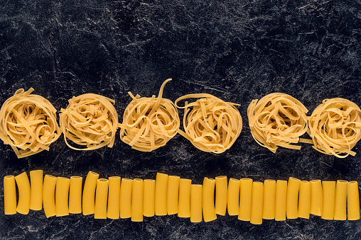 composition of two types of pasta on black concrete table