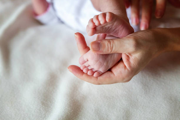 istock Baby feet and mother hands 864774848