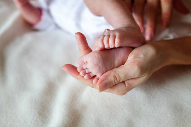 istock Baby feet and mother hands 864774882