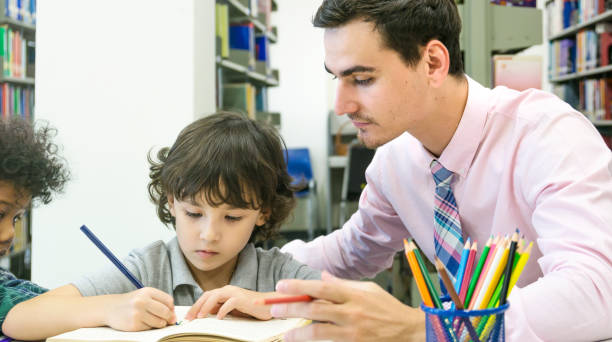 istock teacher and chirld student learning and drawing in the color book with self book background 864793232