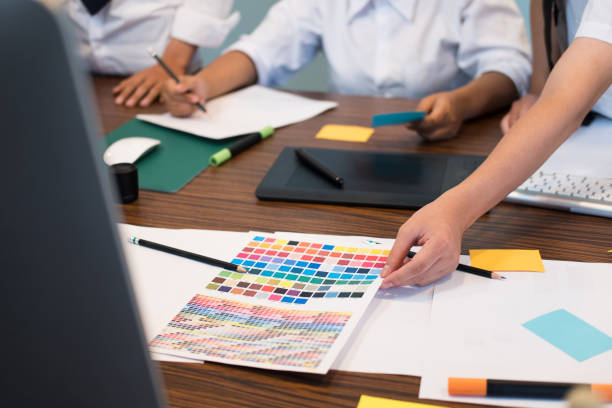 istock graphic or interior designer choosing a colour from color swatch sampler or catalogue palette guide. artist discussing design and idea at office. business people brainstorming for new creativity project. teamwork, partnership concept 864793634