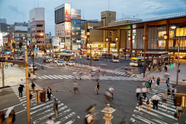 Crowd of people walking across the road in Nagano at dusk, Japan, Asia.