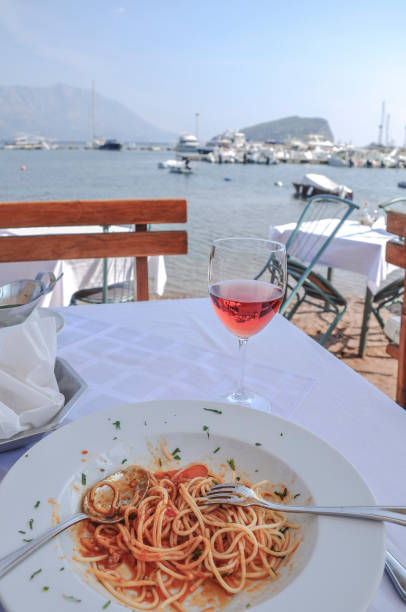 spaghetti and wine glass on table by sea - dining nautical vessel recreational boat europe imagens e fotografias de stock
