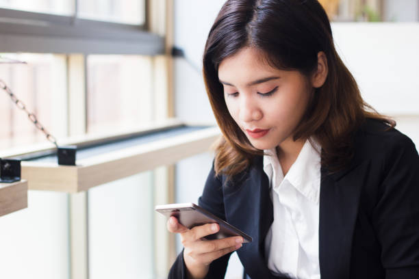 istock Business woman using smartphone checking e-nail, message today. Concept people and technology. Business woman sit by the window and holding mobile phone in her hand. Business people in relax time. 864801388
