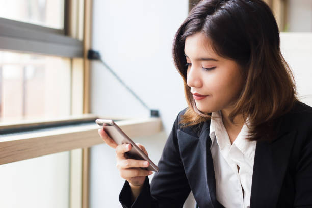 istock Business woman using smartphone checking e-nail, message today. Concept people and technology. Business woman sit by the window and holding mobile phone in her hand. Business people in relax time. 864801394