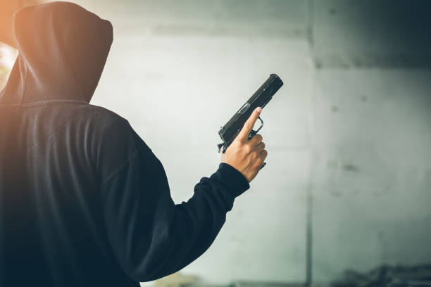 istock Robber holding a gun at abandoned building. 864801504