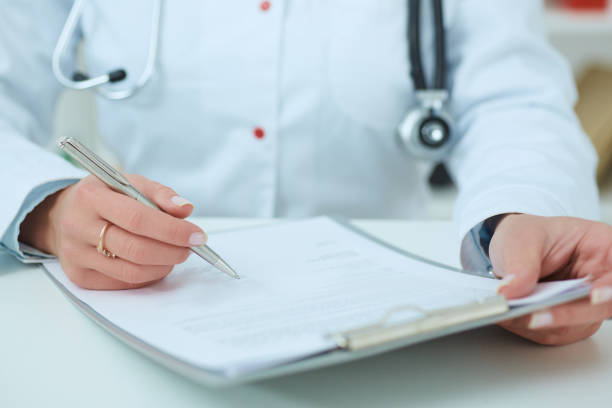 istock Female doctor holding application form while consulting patient. 864804418