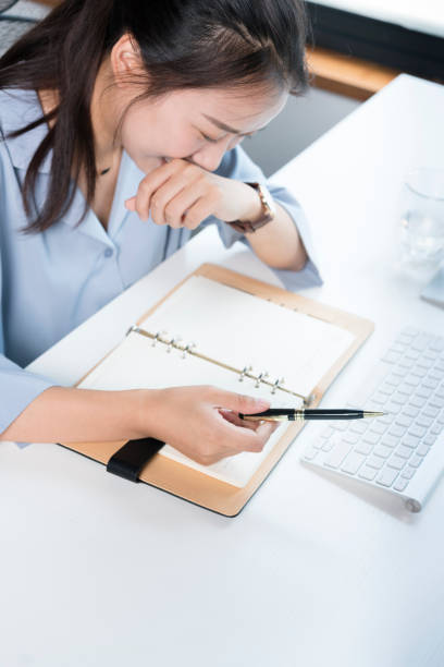 istock young woman writing in notebook by office desk 864808608