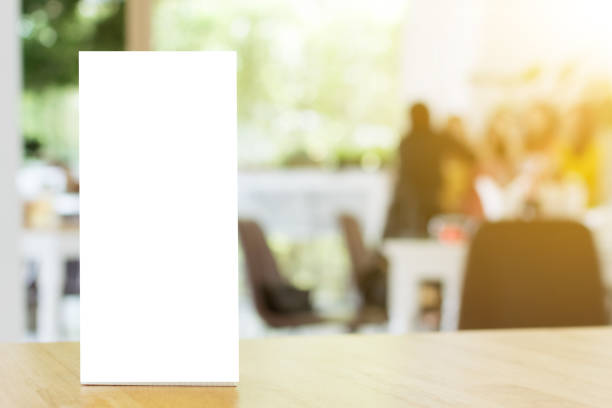 istock Mock up blank template menu frame on wood table in restaurant with blurred background, Clipping path included 864811560