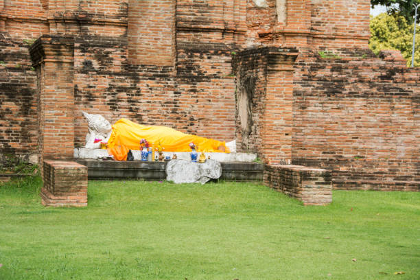 White buddha statue before stone pagodas stock photo